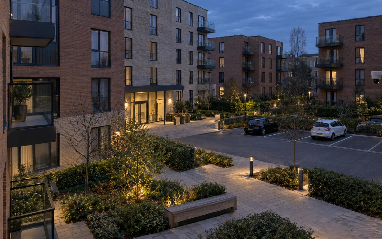 Managed British apartment courtyard at dusk.