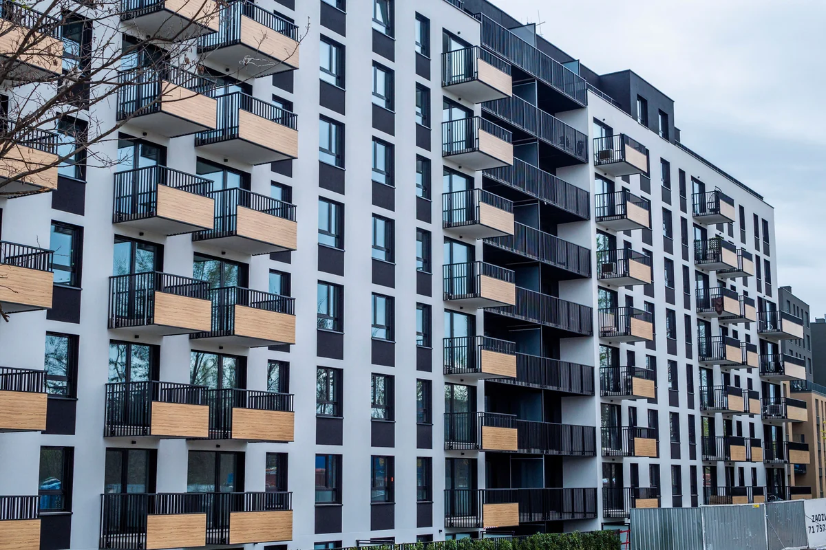 Modern apartment buildings with white and charcoal façades and timber-panelled balconies.