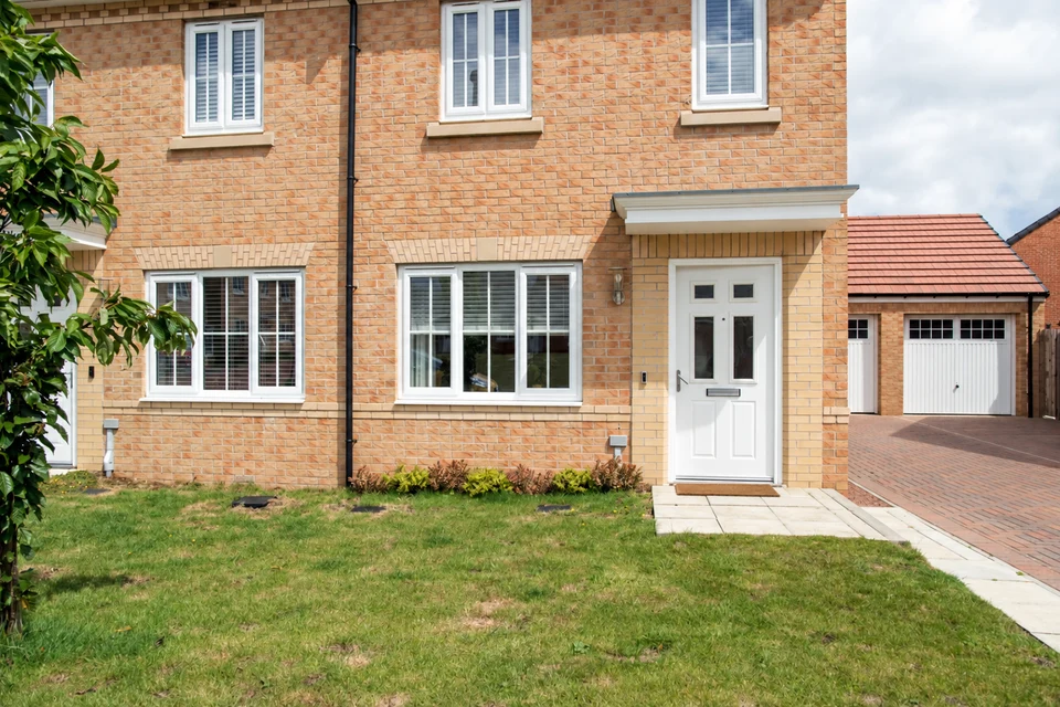 A brick-built home with a front entrance, garden and driveway.