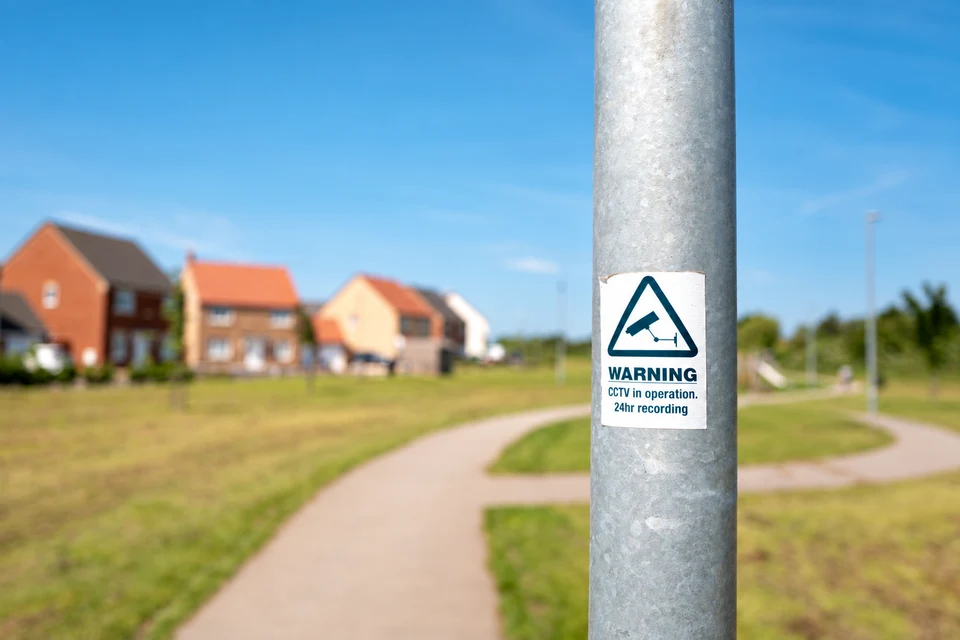 A neighbourhood watch sign beside newly built homes.