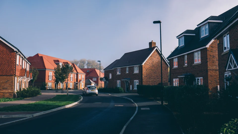 Completed brick-built homes along a landscaped residential street.