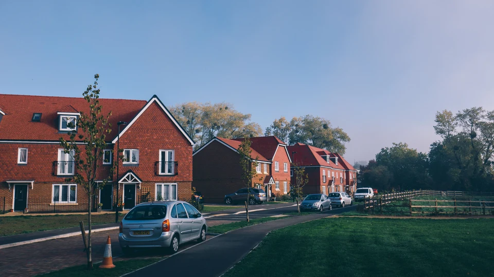 Homes, parked cars and shared green space across a residential development.