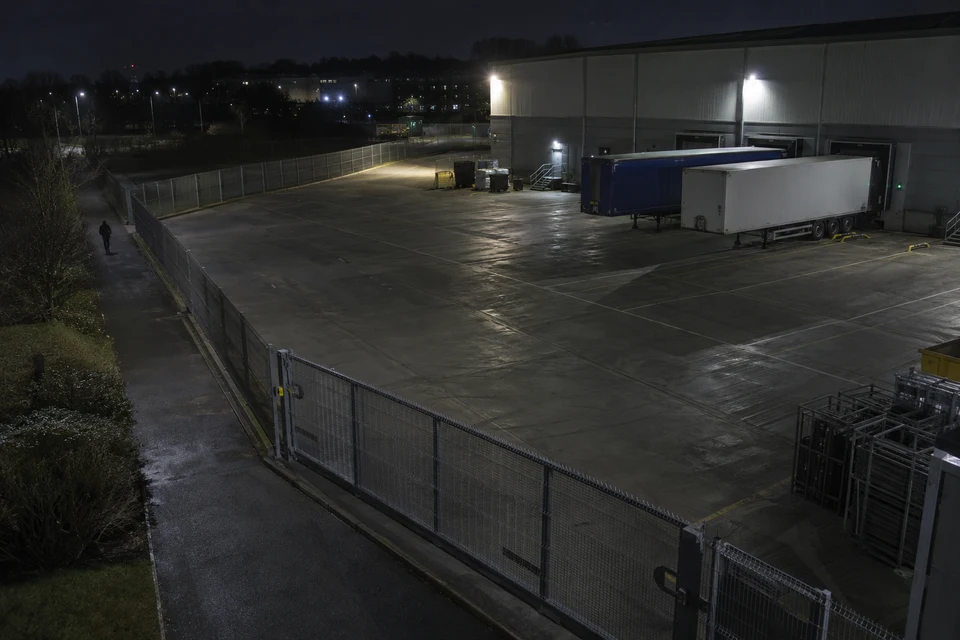 A closed distribution yard with parked trailers and no active operations at night.