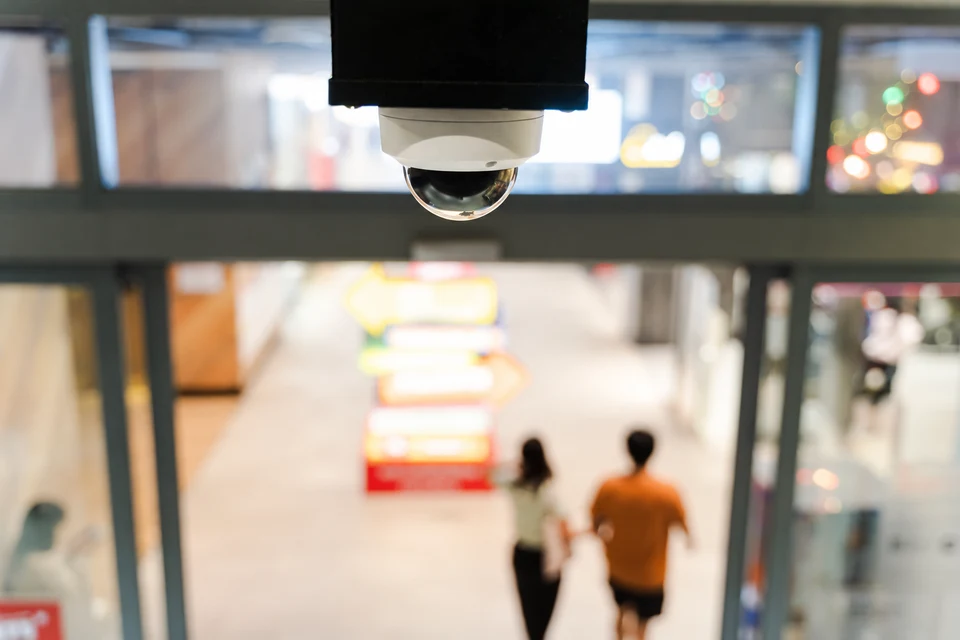 A ceiling-mounted security camera overlooking a shop entrance.