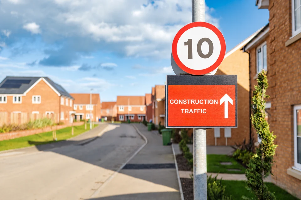 Construction traffic sign on a road through a new housing development.