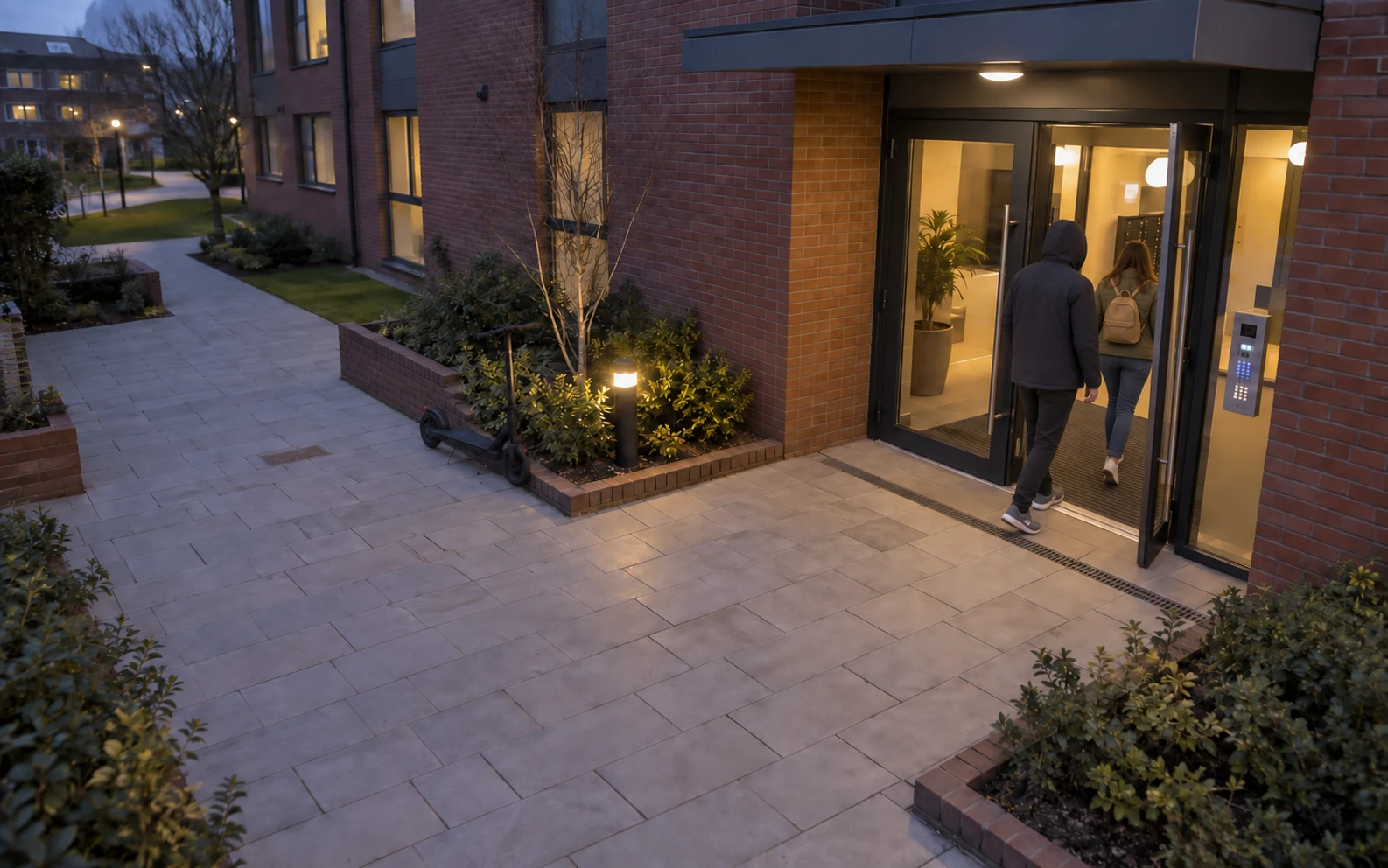 The person follows a resident through the open entrance, leaving the scooter outside.
